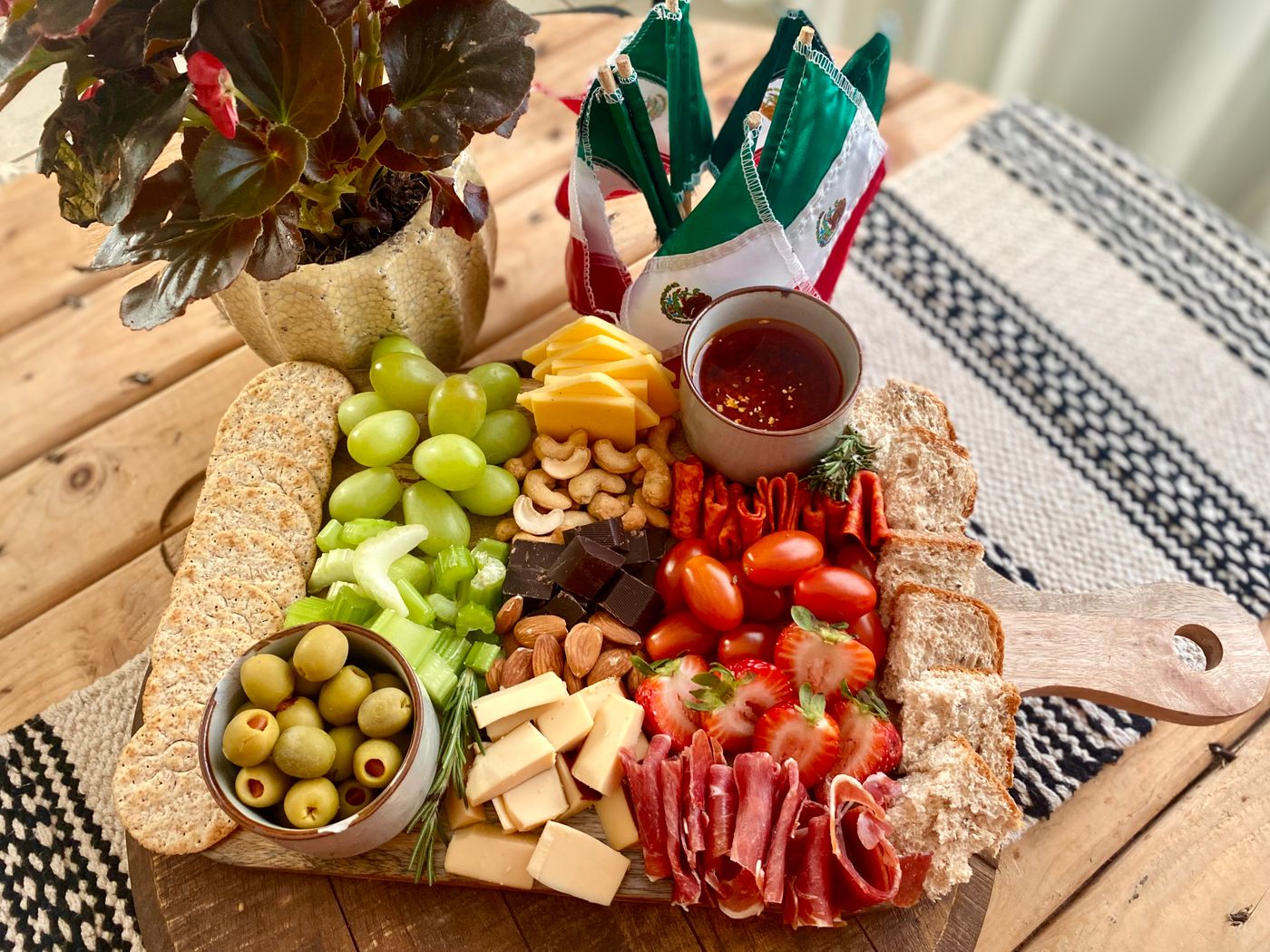 Deli board with cheese, cured meat, fruit and bread